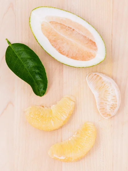 Fresh pomelo cutting and peeled on the wooden background. — Stock Photo, Image