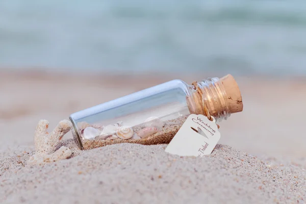 Sand und Muschel in Flaschen an den Strand gestellt — Stockfoto