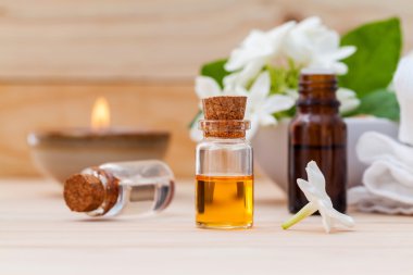 Ahşap backgr Yasemin çiçekleri ile düzenlenmiş aroma yağ şişeleri