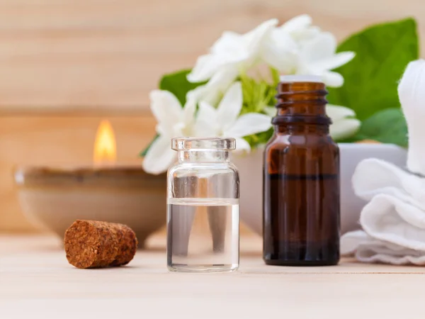 Aroma oil bottles arranged with jasmine flowers on wooden backgr — Stock Photo, Image