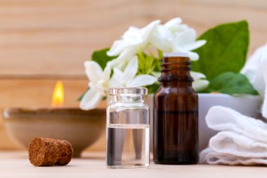 Ahşap backgr Yasemin çiçekleri ile düzenlenmiş aroma yağ şişeleri
