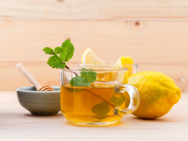 Чашка травяного чая со свежей зеленой мятой, медом и лимоном на дереве — стоковое фото
