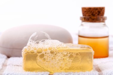 Beyaz banyo havlusu üzerine bitkisel spa sabun çubuğu .