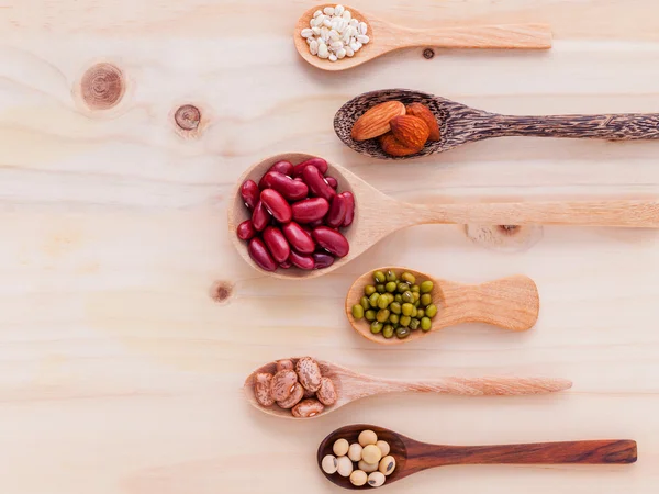 Assortiment de haricots et lentilles en cuillère en bois sur backgr en bois — Photo