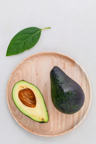 Alternative Gesundheitsfürsorge frische Avocado und Blätter auf Marmorrücken — Stockfoto