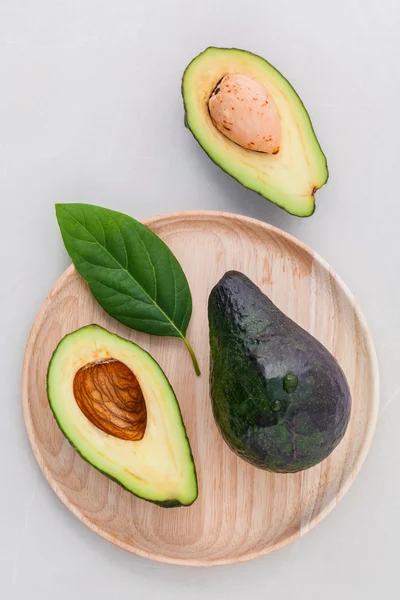 Alternative Gesundheitsfürsorge frische Avocado und Blätter auf Marmorrücken — Stockfoto