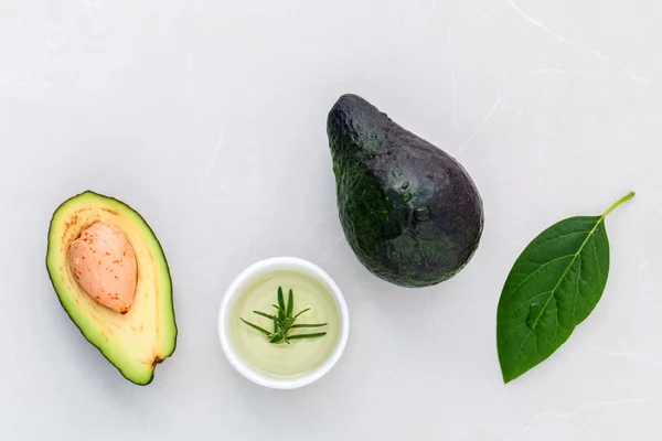 Alternative Gesundheitsfürsorge frische Avocado und Blätter auf Marmorrücken — Stockfoto