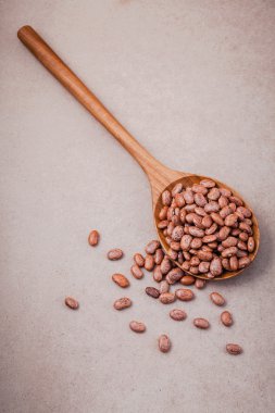 The composition of raw pinto beans in wooden spoon