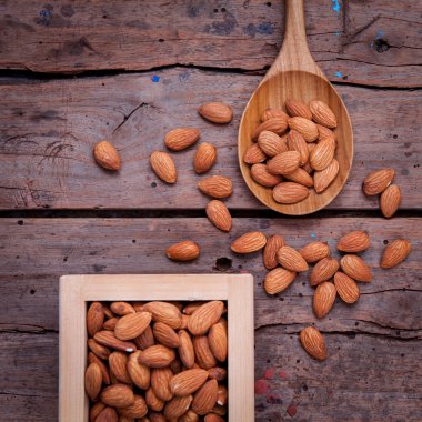 Almonds in wooden box and wooden spoon