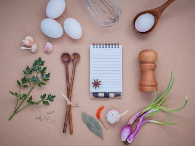 Four white eggs with note book ,pepper bottle ,wooden spoons