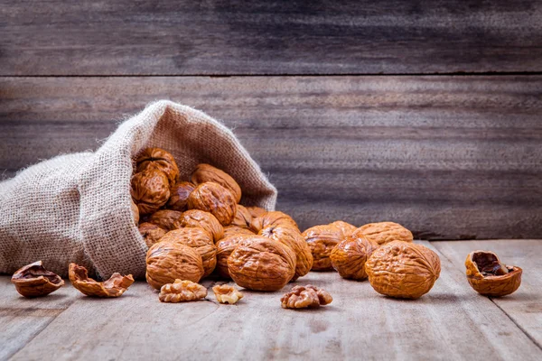 Walnuts kernels in hemp sack and whole walnuts — Zdjęcie stockowe