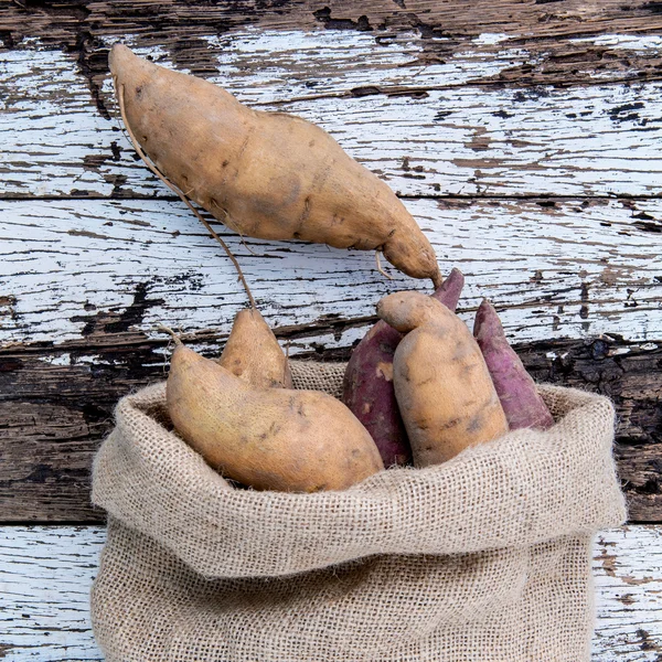 Harvested organic sweet potatoes in a hemp sack bag — Stock Photo, Image