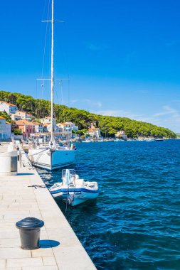 Hırvatistan 'ın Losinj adasındaki Mali Losinj kasabasındaki Adriyatik kıyı şeridinde kıyı ve botlar
