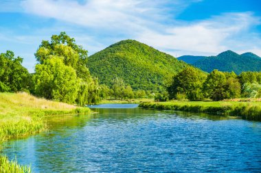 Hırvatistan 'ın Lika bölgesindeki yeşil çayırlar arasında akan güzel Gacka nehri 