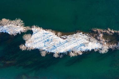 Hırvatistan 'ın Mreznica Nehri' nde kar altında küçük bir ada, kırsal cennet manzarası, insansız hava aracı manzarası