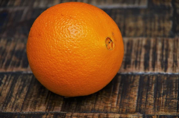 Uma laranja na mesa marrom — Fotografia de Stock