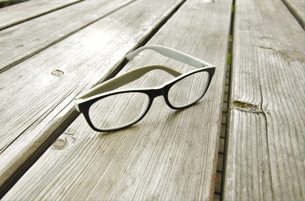 Gafas tumbadas sobre una mesa de madera — Foto de Stock