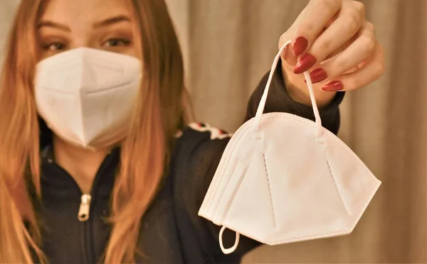 Yeni bir maske takan tıbbi maskeli bir kız.