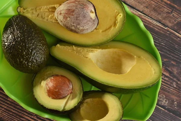 Avocado Geheel Helften Een Groene Kom — Stockfoto