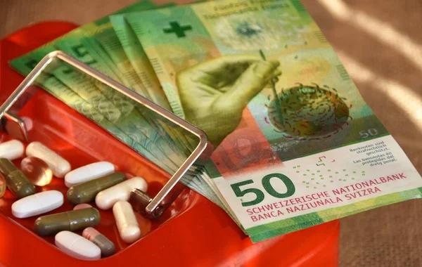 medicine and swiss money on the red safe
