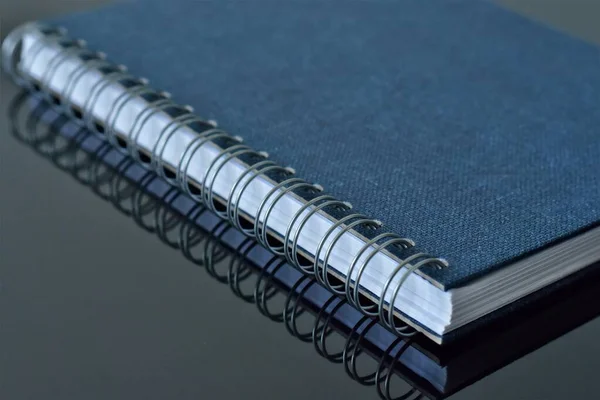 Modrý Notebook Pružinami Černém Skleněném Stole — Stock fotografie
