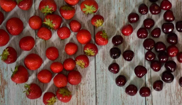 Reife Erdbeeren Und Kirschen Auf Einem Hölzernen Hintergrund — Stockfoto