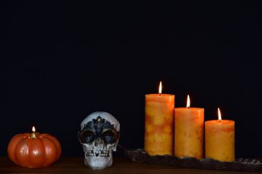 kafatası maskeli ve mumlar siyah arkaplanda