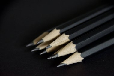 Siyah arkaplanda silgisi olan basit kalemler