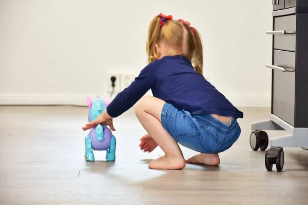 床におもちゃの馬を持つ少女 — ストック写真