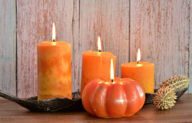 Tahta bir masada yanan fitili olan dört mum.