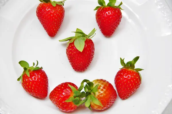 Rode aardbeien op een witte plaat — Stockfoto