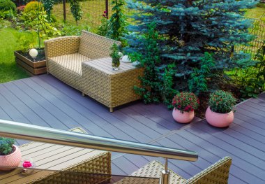 Çiçekler ve hasır mobilyalarla süslenmiş Avrupa tarzı teras ya da kafe. Sürdürülebilir tasarımla çağdaş tasarım