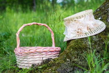 Hasır sepet ve hasır güneş şapkasıyla çimlerin üzerinde piknik. Piknik ve yaz için Rzepna aksesuarları. Eski ve country tarzında bir kartpostal. Kimse.