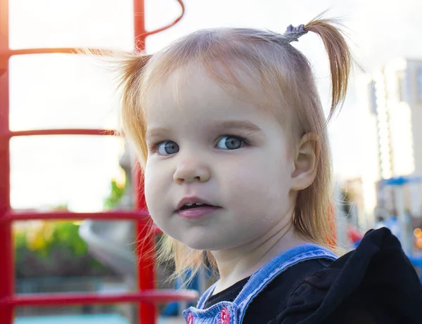 Portrait of Little Beautiful Child Girl with Playground Public Park Playground for children. A kid rejoices at the new playground in new homes. — Stock Photo, Image