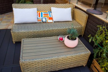 Mekan, bahçede, kamp alanında, doğada bir dinlenme alanı. Ahşap masanın yanındaki rahat kanepe. Bir kır evinin arka bahçesinde dinlenme alanı.