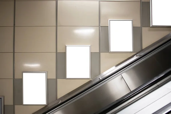 Metro istasyonunun duvarlarında reklamlar asılı..