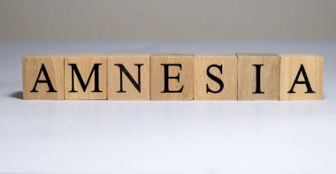 Amnezi kelimesi tahta blokta yazılı. Masada amnezi metni, konsept.