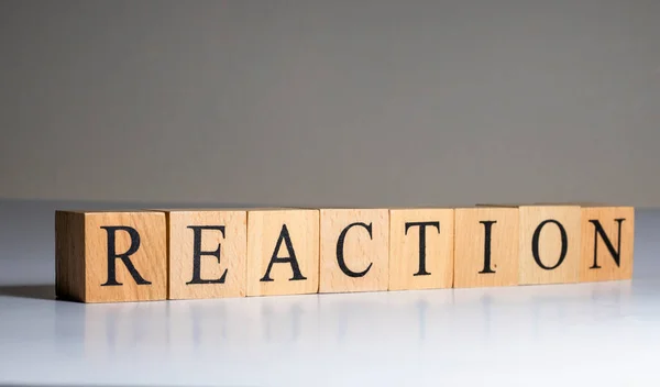 Palabra de reacción en cubo de madera. De cerca.. — Foto de Stock