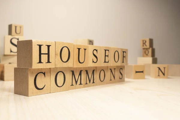House of commons word from wooden cubes. Terms of economy state government. Background made of wooden letters.