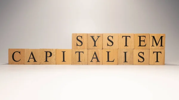 The name Capitalist system was created from wooden letter cubes. finance and economy. close up.