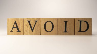 AVOID kelimesi ahşap küplerden yaratıldı. Tüketim ve alışveriş. Yakın plan..