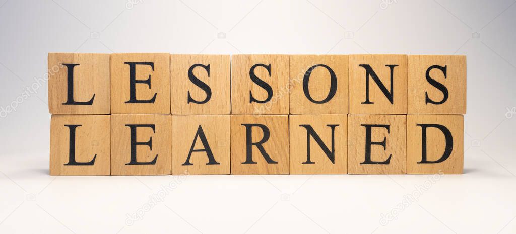 The word Lessons Learned was created from wooden cubes. close up.