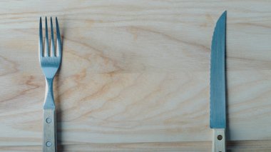 Soldaki çatal, sağdaki bıçak kayın ağacının üstünde, üst görünüm, reklam afişi, metin için yer