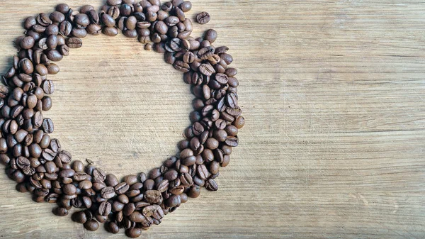 Geröstete Kaffeebohnen Einem Ring Auf Einer Alten Eichentischplatte Verstreut Draufsicht — Stockfoto