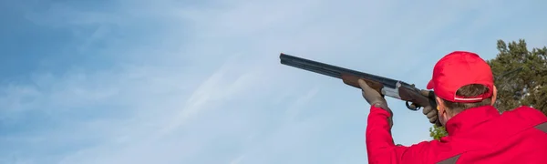 散弾銃の男とトレンチスタンドでスケートを撃つ屋外で撃つ 空中ケーシングで銃クラブで粘土鳩の標的を撃つ — ストック写真
