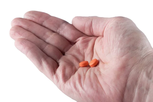 Kırmızı haplar bir adamın buruşuk avucunda yatıyor, makro.