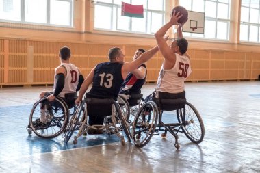 Minsk, Belarus, 31 Mart 2019. Tekerlekli sandalyeli insanlar spor salonunda basketbol oynuyor.