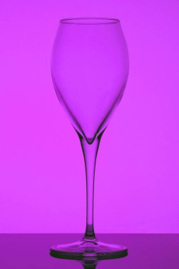 Mor arka planda bir kadeh şarap.