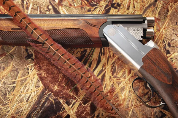 Çift namlulu av tüfeği ve iki mavi fişek, yakın plan. 