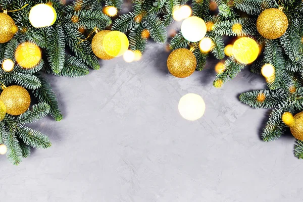 Fondo de hormigón de Navidad con abeto y juguetes dorados y luces. — Foto de Stock